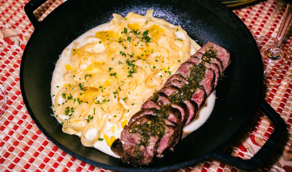 Fettuccine ao molho branco acompanhado de carne nobre fatiada no Restaurante Nonna Marta em Atins.