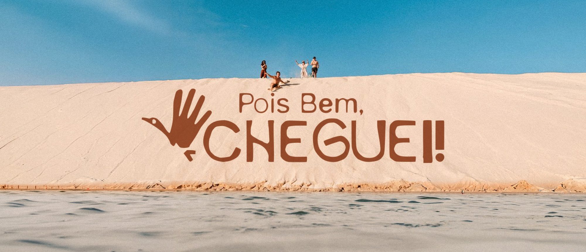 Duna de Atins com o logo Pois Bem, Cheguei pintado na areia e um grupo de pessoas no alto da duna