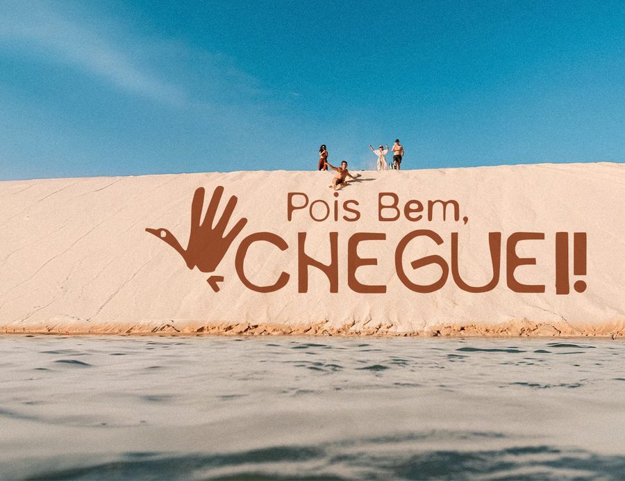 Duna de Atins com o logo Pois Bem, Cheguei pintado na areia e um grupo de pessoas no alto da duna